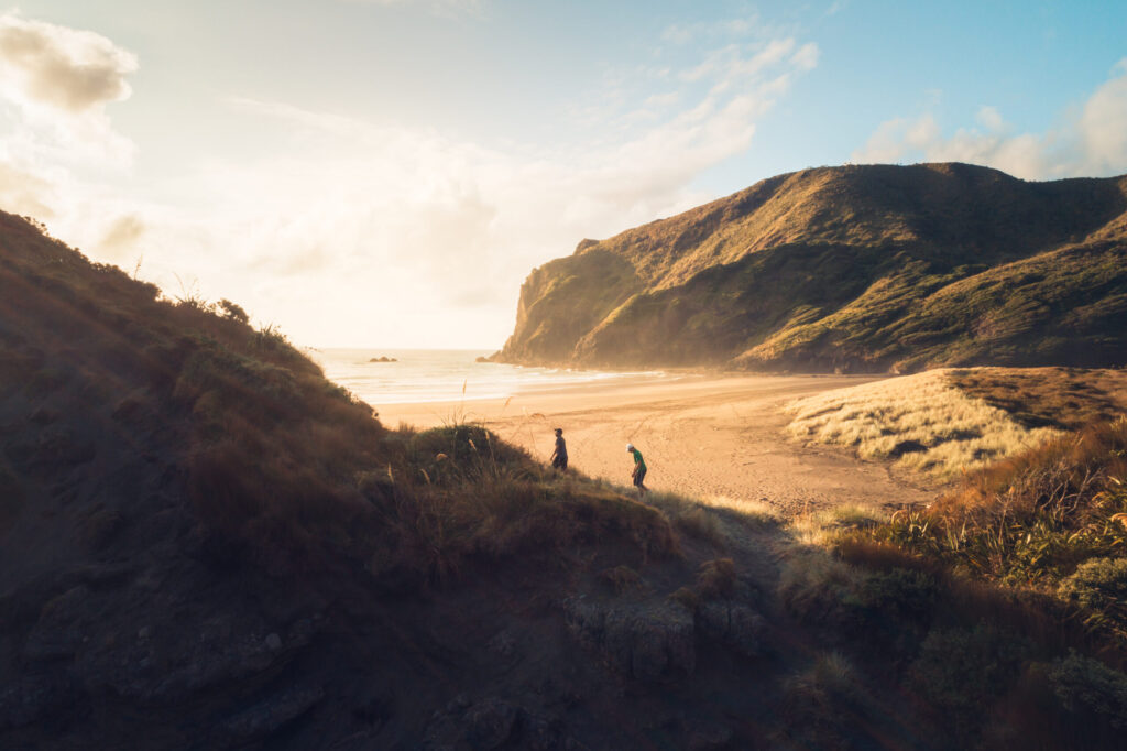 Two people walking up a seaside path