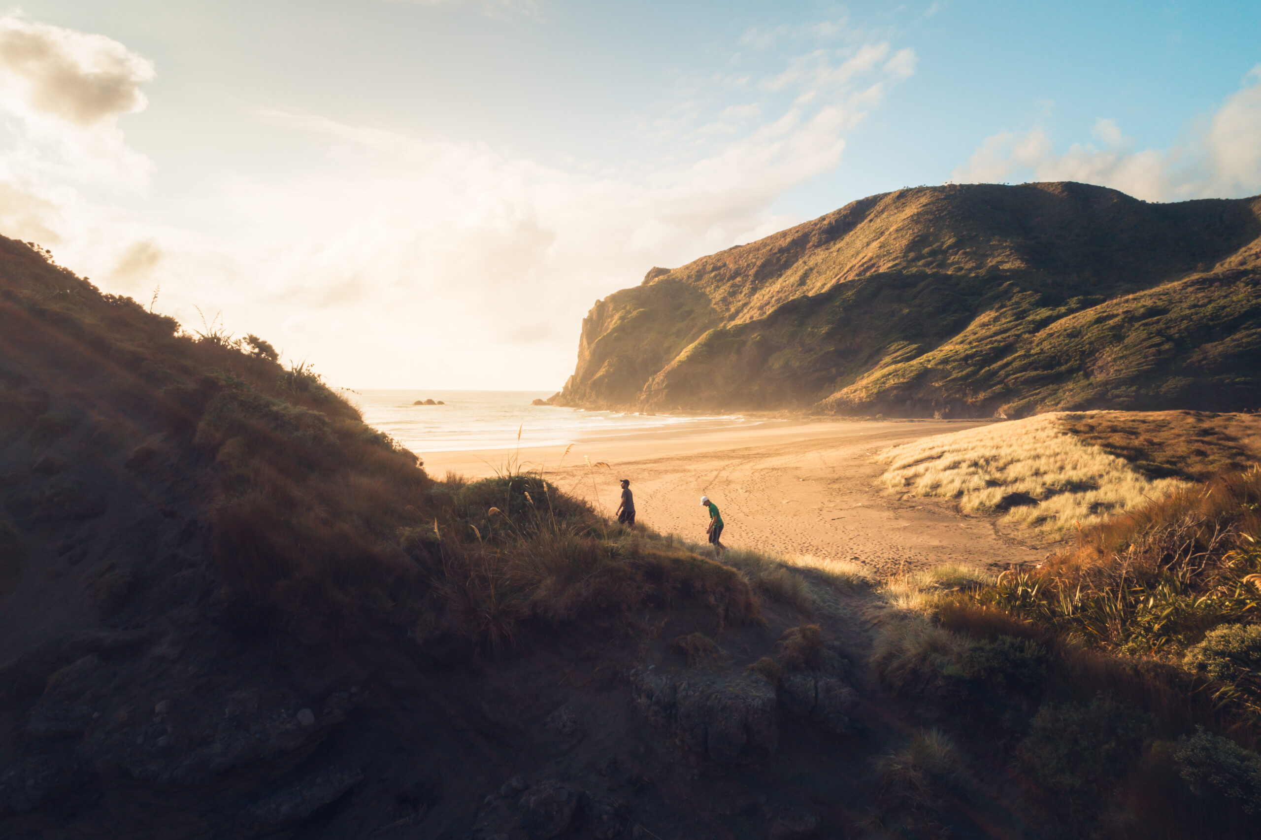 Two people walking up a seaside path
